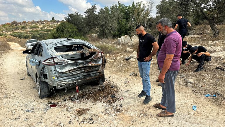 Palestinians assess the damage of a car during a military operation by Israeli forces near Jenin in the Israeli-occupied West Bank August 28, 2024. REUTERS/Ali Sawafta