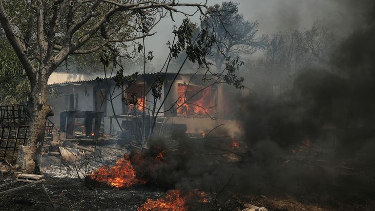 A house is seen in flames as a wildfire burns in Nea Penteli.
Pic: Reuters