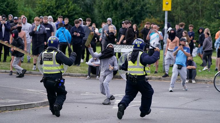 A youth aims a fence post towards police during an anti-immigration demonstration near the Holiday Inn Express in Rotherham, South Yorkshire. Picture date: Sunday August 4, 2024.

