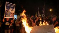 Protesters gather around a fire during a protest in Tel Aviv. Pic: Reuters