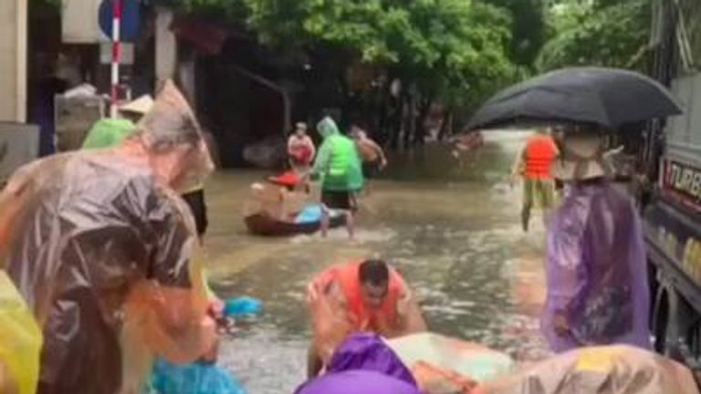 Residents were navigating the streets of northern Vietnam in boats as tens of thousands were evacuated.