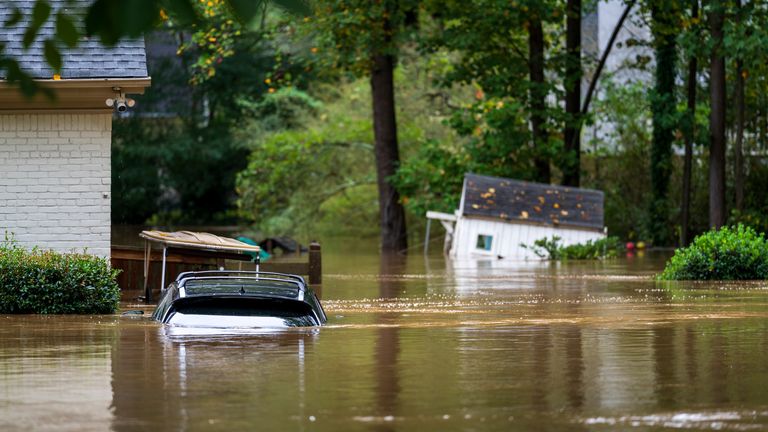 A vehicle, a golf cart and a playhouse are inundated by floodwaters in Atlanta on Friday, September 27, 2024. (AP Photo/Jason Allen)