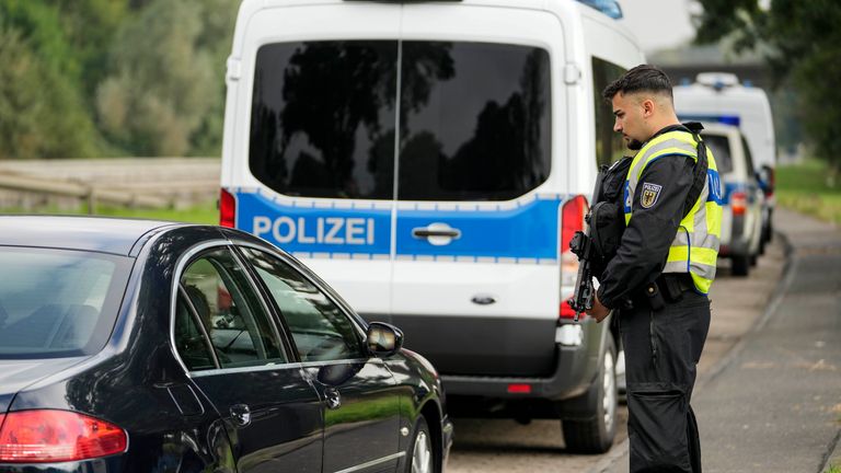 An armed German police officer checks the details of a French car near the border to Belgium in Aachen, Germany.
Pic: AP