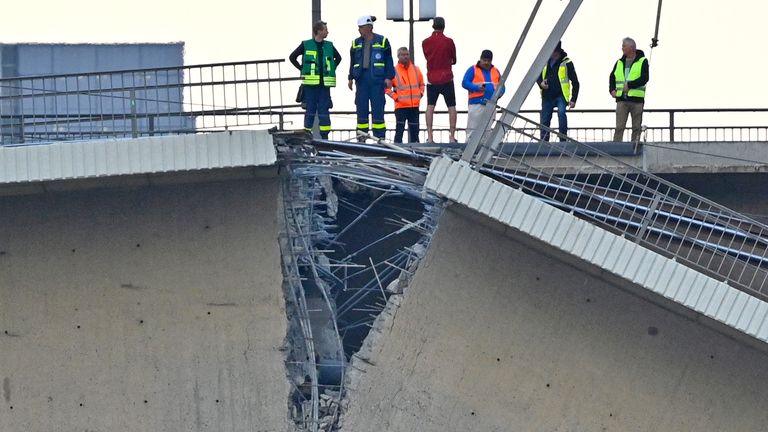 People look at the broken part of the Carola Bridge (Carolabruecke) which collapsed into the Elbe, in Dresden, Germany September 11, 2024. REUTERS/Matthias Rietschel