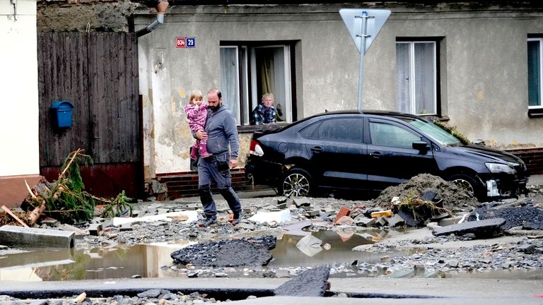 People walk through debris after recent floods in Jesenik, Czech Republic.
Pic: AP