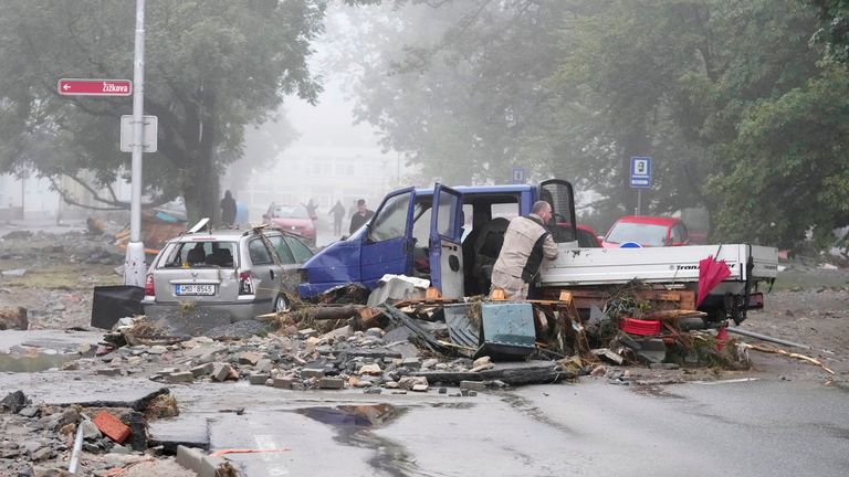 A resident looks at his damaged car after recent floods in Jesenik, Czech Republic.
Pic: AP