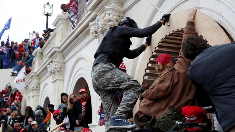 Trump supporters scale the wall of the Capitol Building in Washington DC on 6 January 2021. Pic: Reuters