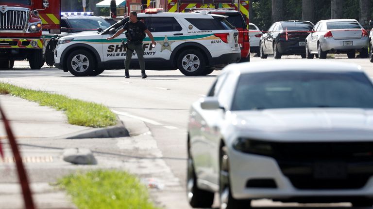 A police officer gestures as they investigate reports of shots fired outside Republican presidential nominee and former U.S. President Donald Trump's Trump International Golf Course in West Palm Beach, Florida, U.S. September 15, 2024. REUTERS/Marco Bello
