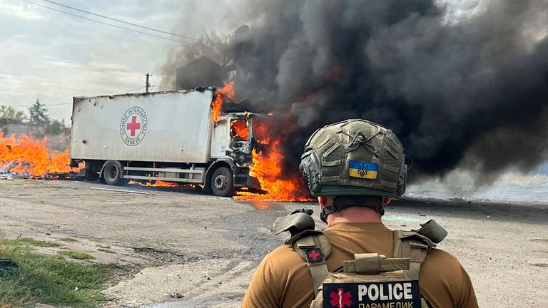 A Ukrainian police officer looks at the burning cargo truck. Pic: AP