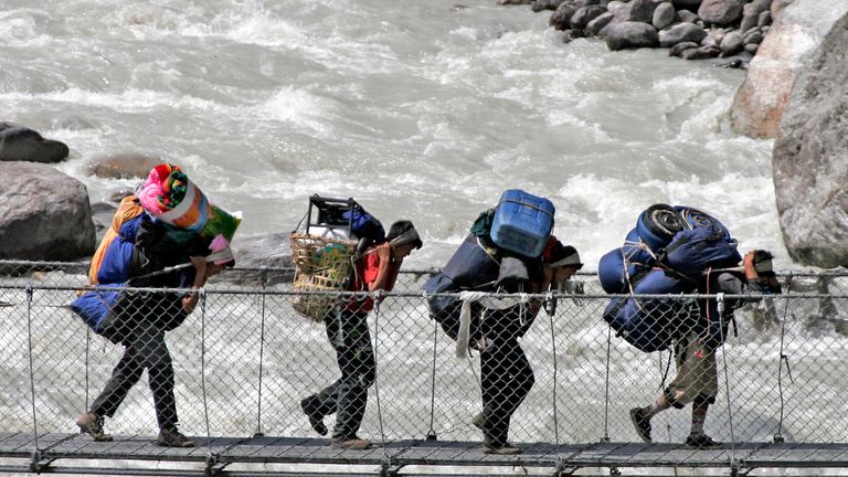 Porters walk across a bridge over the Bhote Koshi river in the Everest region. File pic: Reuters
