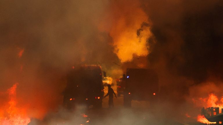 Firefighters try to extinguish a wildfire on a road in Junqueiro, Agueda, Portugal. Pic: Reuters