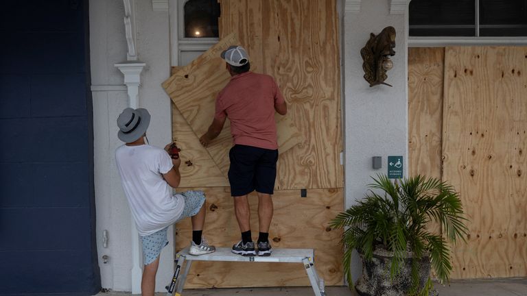 Men board up a restaurant window in Cedar Key, Florida. Pic: Reuters