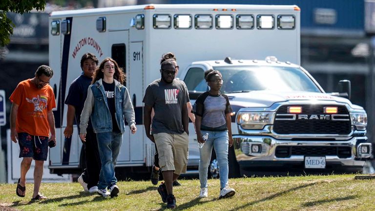 Students and parents walk off campus at Apalachee High School, Wednesday, Sept. 4, 2024, in Winder, Ga. (AP Photo/Mike Stewart)