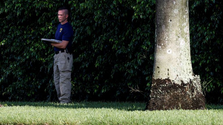 A law enforcement official works at the perimeter of Trump International Golf Club.
Pic: Reuters