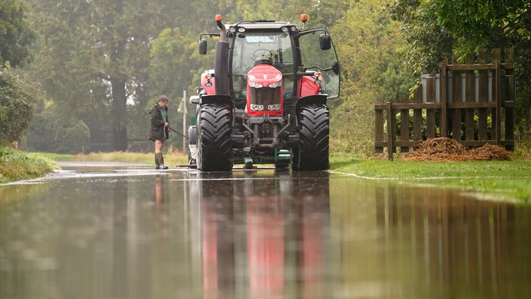 A tractor pulling a vehicle which is stuck in flood water in Grendon, Northamptonshire. Pic: PA