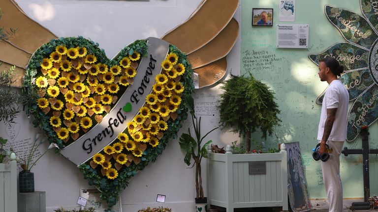 A person views dedications and messages on a wall of condolences near to the covered remains of Grenfell Tower, on the day of the publication of the second report of the UK public inquiry into the deadly 2017 Grenfell fire, in London, Britain, September 4, 2024. REUTERS/Toby Melville
