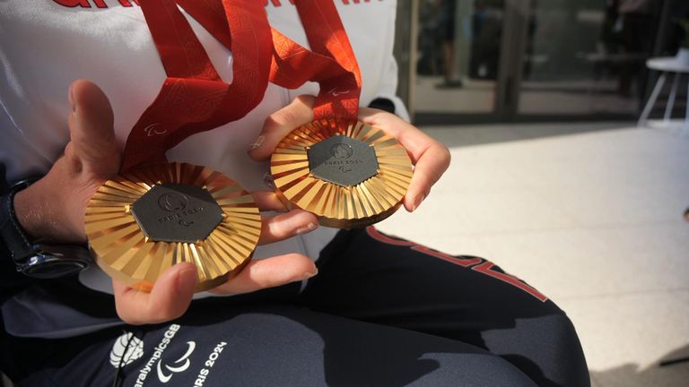 Hannah Cockcroft - now a nine-time Paralympic champion in wheelchair racing - shows off her gold medals from Paris 2024