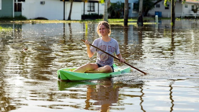 Halle Brooks kayaks along a street flooded by Hurricane Helene in the Shore Acres neighborhood on Friday, Sept. 27, 2024, in St. Petersburg, Fla. (AP Photo/Mike Carlson)