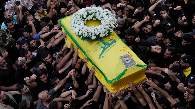 Miembros de Hezbolá llevan el ataúd de su camarada que murió el miércoles cuando explotó un dispositivo de mano, durante una procesión fúnebre en los suburbios del sur de Beirut, el jueves 19 de septiembre de 2024. (Foto AP/Hussein Malla)