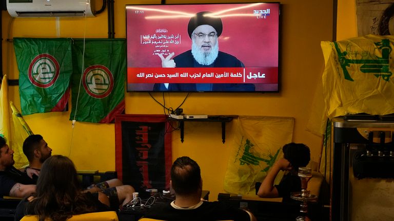 La gente observa el discurso del líder de Hezbolá, Hassan Nasrallah, mientras están sentados en un café en los suburbios del sur de Beirut, el jueves 19 de septiembre de 2024. (Foto AP/Hassan Ammar)