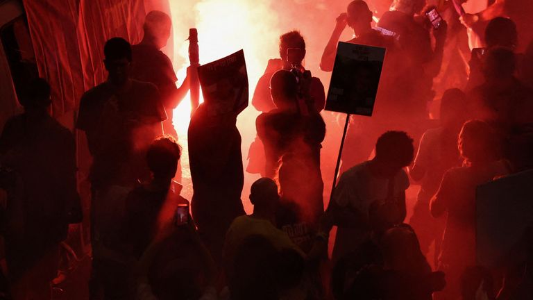 A flare burns on the third night of protests as Israelis demand a ceasefire deal to free the remaining hostages. Pic: AP