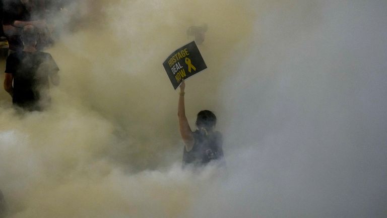 A demonstrator holds a sign calling for an immediate ceasefire deal amid protests on Tuesday night. Pic: AP