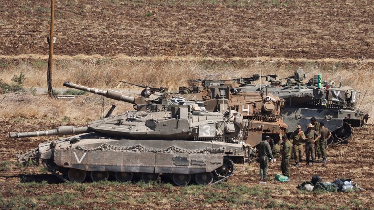 People stand next to Israeli Army tanks, amid cross-border hostilities between Hezbollah and Israel, in northern Israel, September 27, 2024. REUTERS/Jim Urquhart