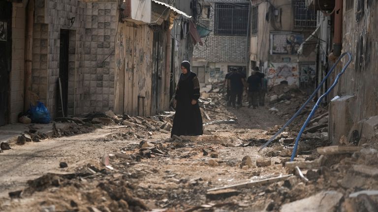 Palestinians walk on a damaged road following an Israeli military operation in the West Bank city of Jenin on Friday, Sept. 6, 2024. (AP Photo/Majdi Mohammed)