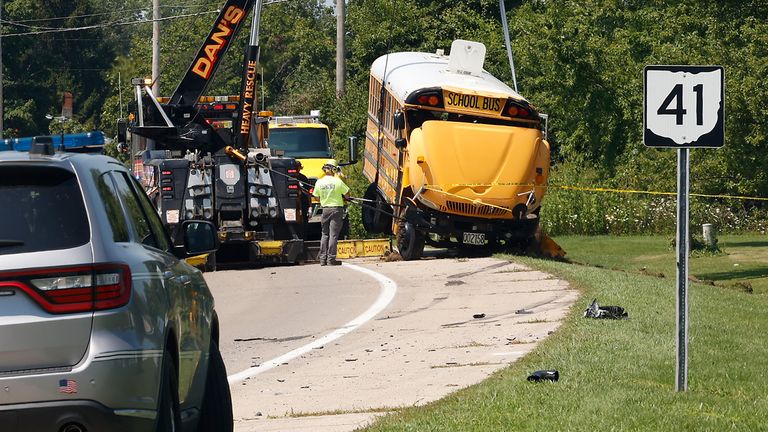 A Northwestern School District bus is uprighted by a crane after it was involved in a crash with another vehicle and rolled over in Lawrenceville, Ohio, Tuesday, Aug. 22, 2023. (Bill Lackey/The Springfield News-Sun via AP)