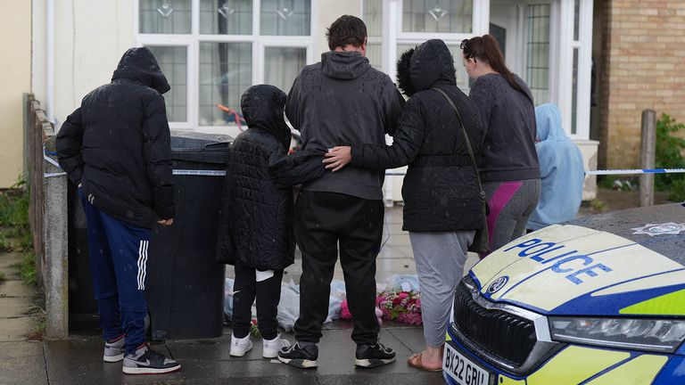 A group of people look at the   tributes left at the scene of a house fire in Bedale Drive, Leicester.
Pic PA

