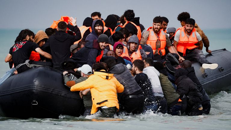 Migrants trying to cross the English Channel to reach Britain board an inflatable rubber boat as French police and gendarmes patrol the beach at the Slack Dunes in Wimereux, France, September 4, 2024. REUTERS/Benoit Tessier TPX IMAGES OF THE DAY