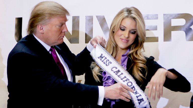 Donald Trump, the owner of the Miss Universe Organization, gives Miss California USA, Carrie Prejean, her sash during a news conference announcing that Prejean would retain her title in New York May 12, 2009. Prejean had been the recent subject of controversy regarding photographs from earlier in her modeling career and statements regarding marriage she made during the Miss USA pageant. BEST QUALITY AVAILABLE   REUTERS/Lucas Jackson (UNITED STATES ENTERTAINMENT BUSINESS)