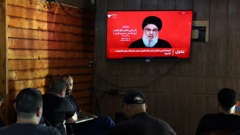 People watch Lebanon's Hezbollah leader Sayyed Hassan Nasrallah delivering a televised address, as they sit at a cafe in Beirut, Lebanon September 19, 2024. REUTERS/Mohamed Azakir