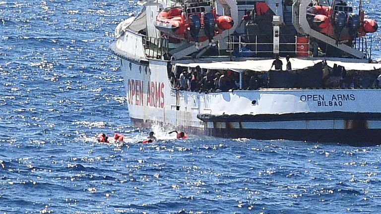 Migrants swim after jumping off the Open Arms. Pic: Reuters