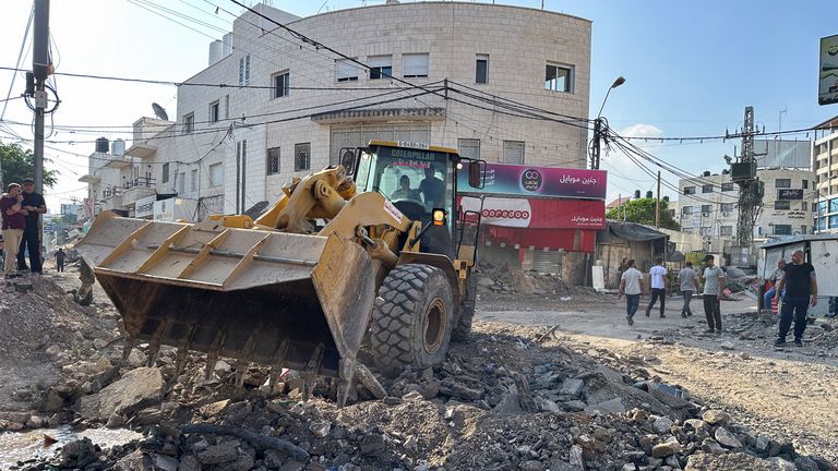 Palestinians operate a machinery to remove rubble from the street following an Israeli military operation in Jenin in the Israeli-occupied West Bank September 6, 2024. REUTERS/Ali Sawafta
