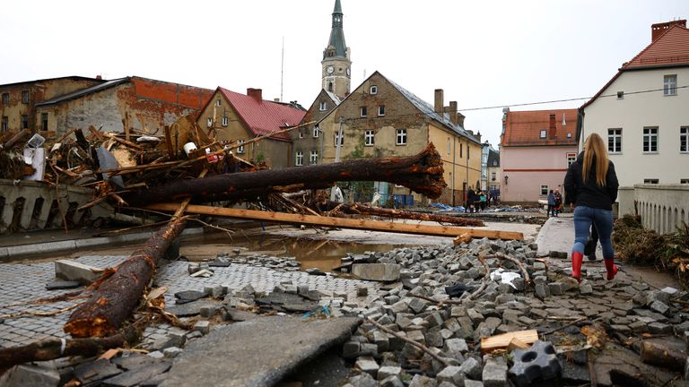 A woman walks through a destroyed bridge in the aftermath of flooding by the Biala Ladecka River in Ladek Zdroj, Poland. Pic: Reuters