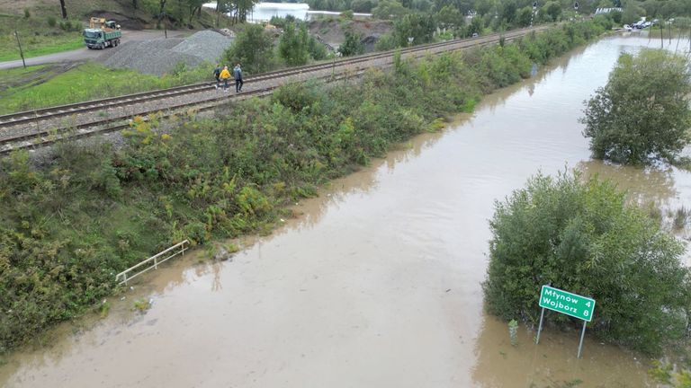 People walk along the train tracks amid flooding in Klodzko, Lower Silesia region, Poland .
Pic: Reuters