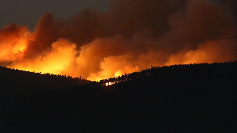 A fire rages on the hills around Sever do Vouga, a town in northern Portugal that has been surrounded by forest fires, Tuesday night, Sept. 17, 2024. (AP Photo/Bruno Fonseca)