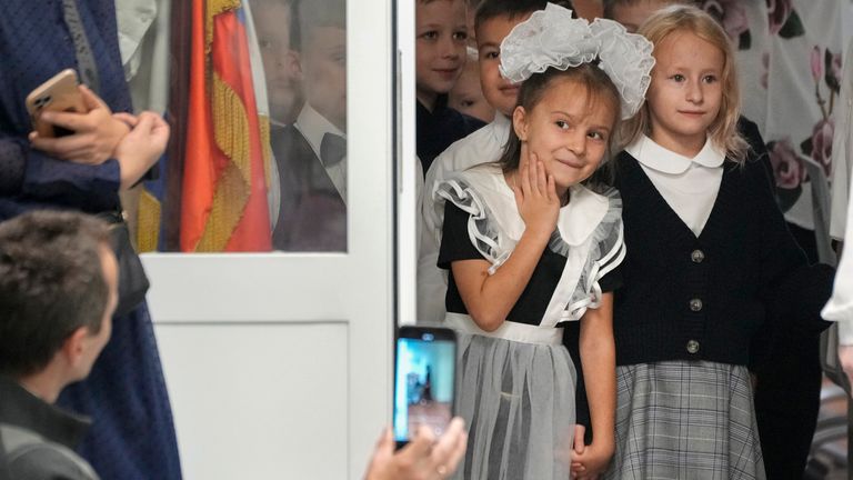 First graders enter a school to take part in a ceremony marking the start of classes as part of the traditional opening of the school year known as "Day of Knowledge" in St. Petersburg, Russia, Monday, Sept. 2, 2024. (AP Photo/Dmitri Lovetsky)