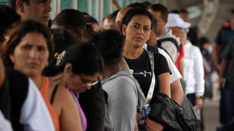 A MIGRANT WAITS FOR HER TURN TO BE CHECKED AT THE US BORDER WITH MEXICO