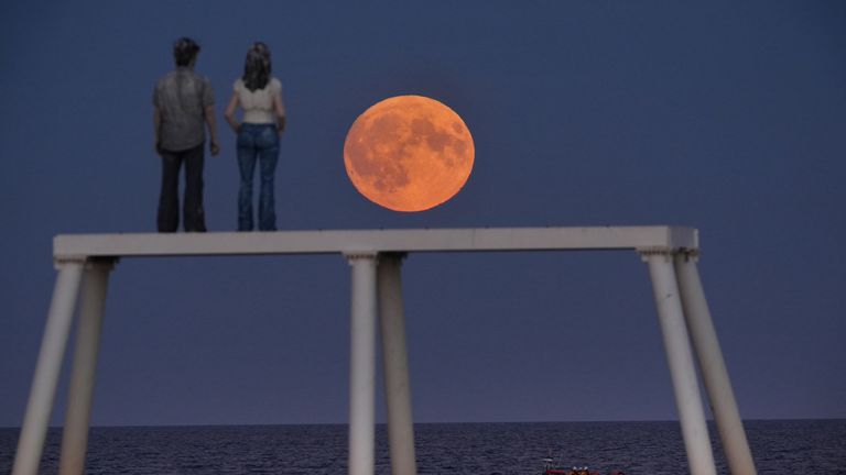 The supermoon rises over 'The Couple' sculpture at Newbiggin-by-the-Sea in Northumberland. Pic: PA