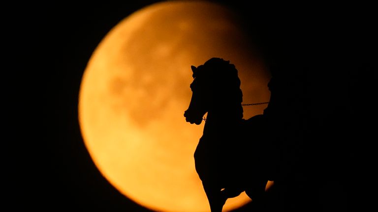 A supermoon rises behind a horse statue on the Arc de Triomphe during the partial lunar eclipse in Moscow, Russia. Image: AP