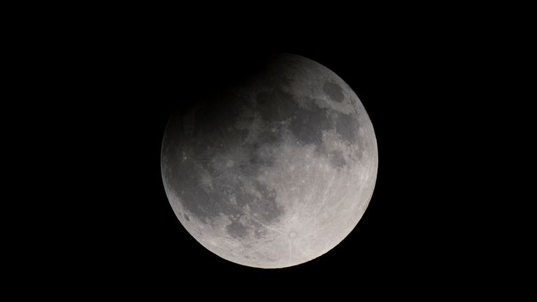 A partial solar eclipse obscures a rising supermoon in Nashville, Tennessee