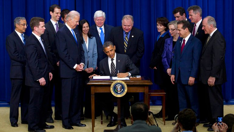 Walz (centre back) watches as President Barack Obama signs new legislation with his Vice President Joe Biden in 2012. Pic: AP