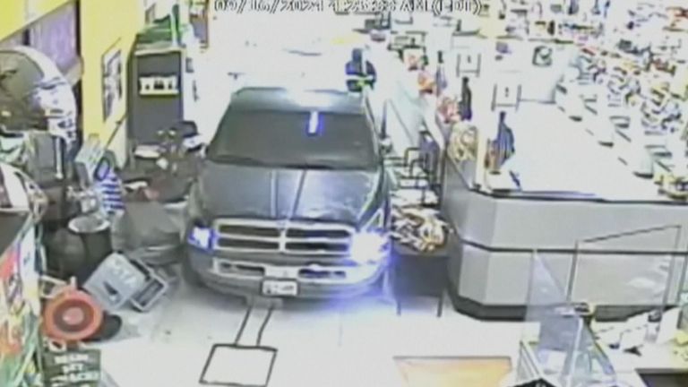 A security camera captured the moment three robbers slammed the back of the truck into a grocery shop.