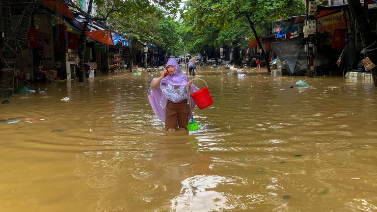 A woman wades through a flooded street following the impact of Typhoon Yagi, in Thai Nguyen City, Vietnam, September 11, 2024. REUTERS/Thinh Nguyen TPX IMAGES OF THE DAY