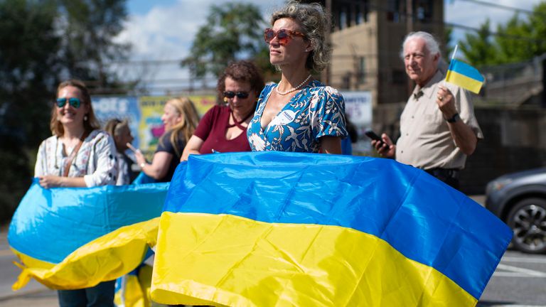 Un pequeño grupo de simpatizantes ondeó banderas ucranianas durante la visita de Zelenskyy a la planta de municiones. Foto: AP