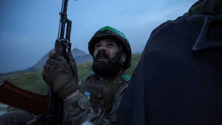 A member of Ukraine's 25th Separate Airborne Brigade keeps an eye on the sky as he rides in a car near the front line. Pic: Reuters