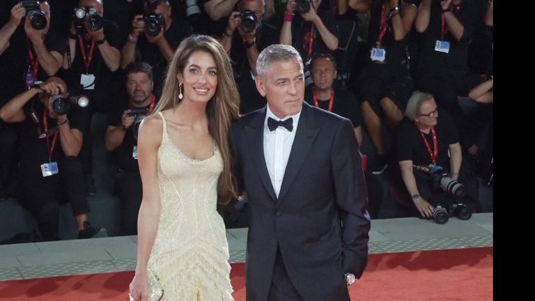 Clooney helps up fallen photographer after he trips at Venice premiere