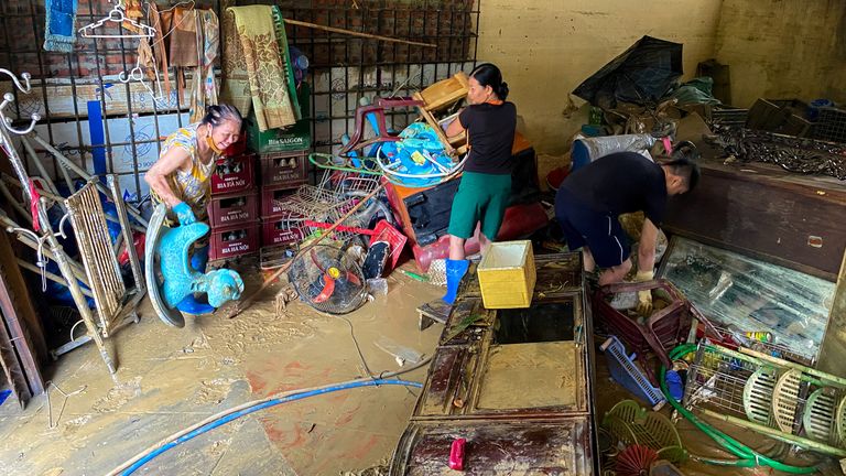 A family works to clean the mud in Thai Nguyen City, Vietnam. Pic: reuters